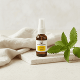 Catnip spray bottle on a white surface with a plant leaf