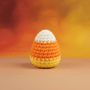 Crocheted candy corn toy on a warm-toned background