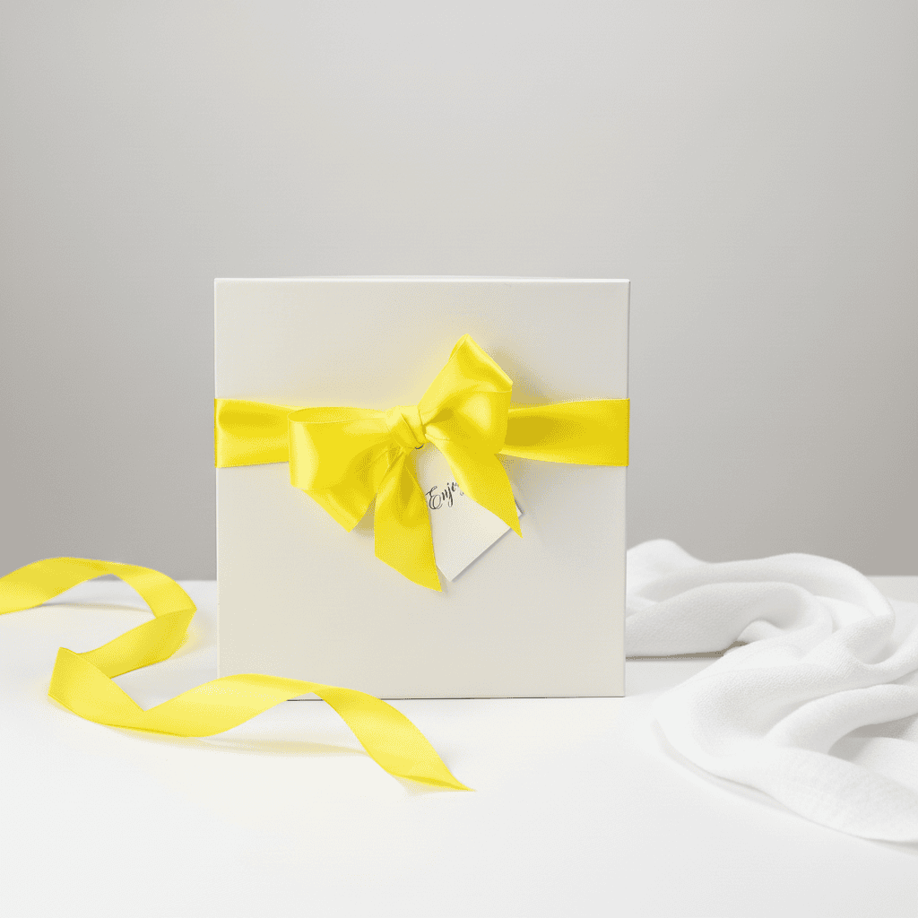 White gift box with a yellow ribbon on a light gray background