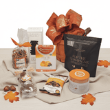 Gift basket with various items including a box of tea, cookies, and package of champagne popcorn on a white background.