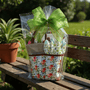 Gift basket with floral garden bag and green bow on a wooden bench outdoors