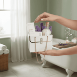 Person holding a white mini purse gift bag with skincare products in a bathroom setting