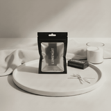 Lumenut cotton wicks packaging on a white surface with a wax pearl candle and a white cloth.