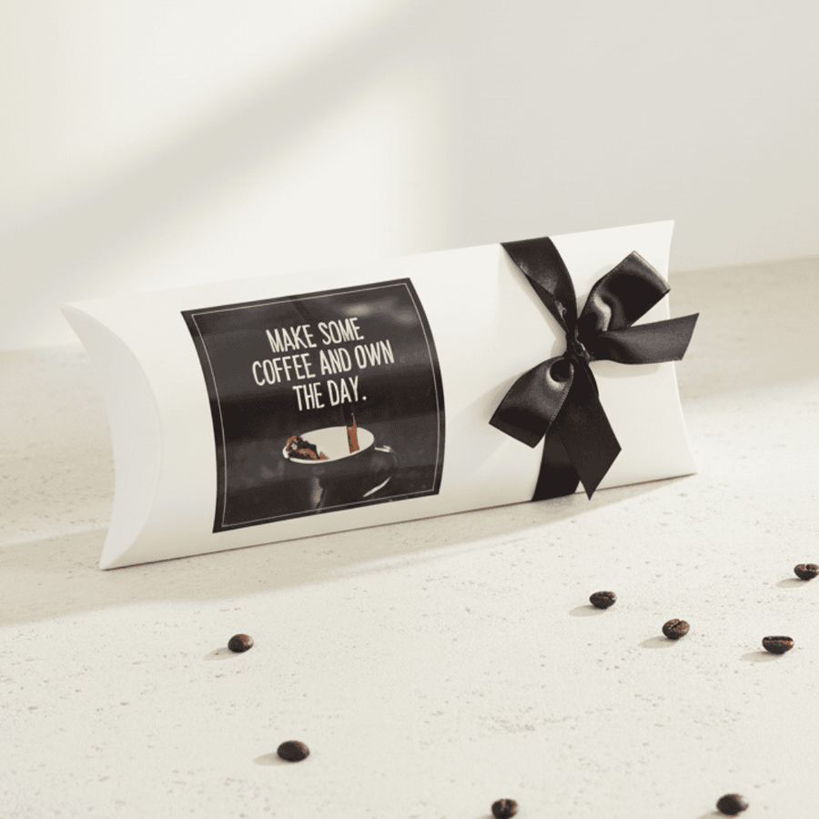 Decorative pillow with a black bow and coffee-themed design on a light surface.