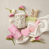 Tea-themed products including a floral mug, and tea packaging on a neutral background with flowers