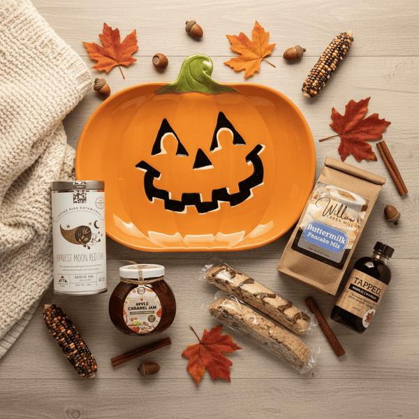 Pumpkin-shaped plate with carved face and breakfast items surrounded by autumn-themed items on a wooden surface