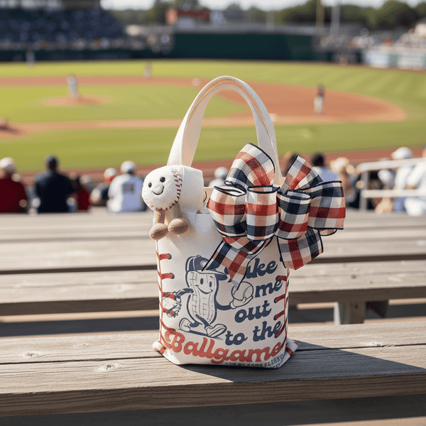 Baseball-themed tote bag with a bow on a wooden bench at a baseball stadium.