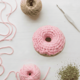 Crocheted donut catnip toy with pink frosting, made for cats. Contains organic catnip and silver vine blend. Durable and handmade, supports cat rescues.
