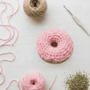 Crocheted donut catnip toy with pink frosting, made for cats. Contains organic catnip and silver vine blend. Durable and handmade, supports cat rescues.