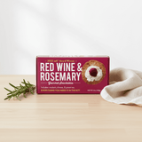 Box of Red Wine & Rosemary Gourmet Snackables on a wooden surface with a white background