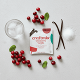 Craftmix Cranberry Vanilla package with cranberries, a vanilla bean, and a glass of water on a light surface.