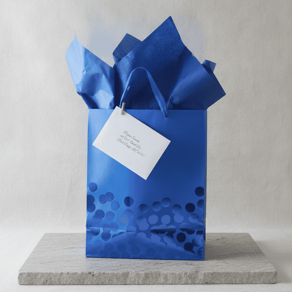 Blue gift bag with crinkled paper and a white custom note card