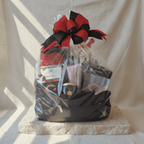 Wrapped sports themed gift basket in clear cellophane with red and black ribbon bow