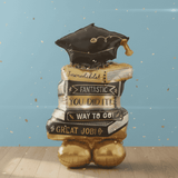 Graduation-themed balloon with books and a cap on a blue background