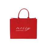 Merry Everything Red Tote: Chic red felt tote bag featuring white text, ideal for stylish shopping. Dimensions: 15-3/4 W x 11-3/4 H x 5-7/8 D.