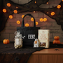 Halloween-themed setup with a mini black canvas tote bag, chocolate candy, and  butter toffee pretzel on a table.